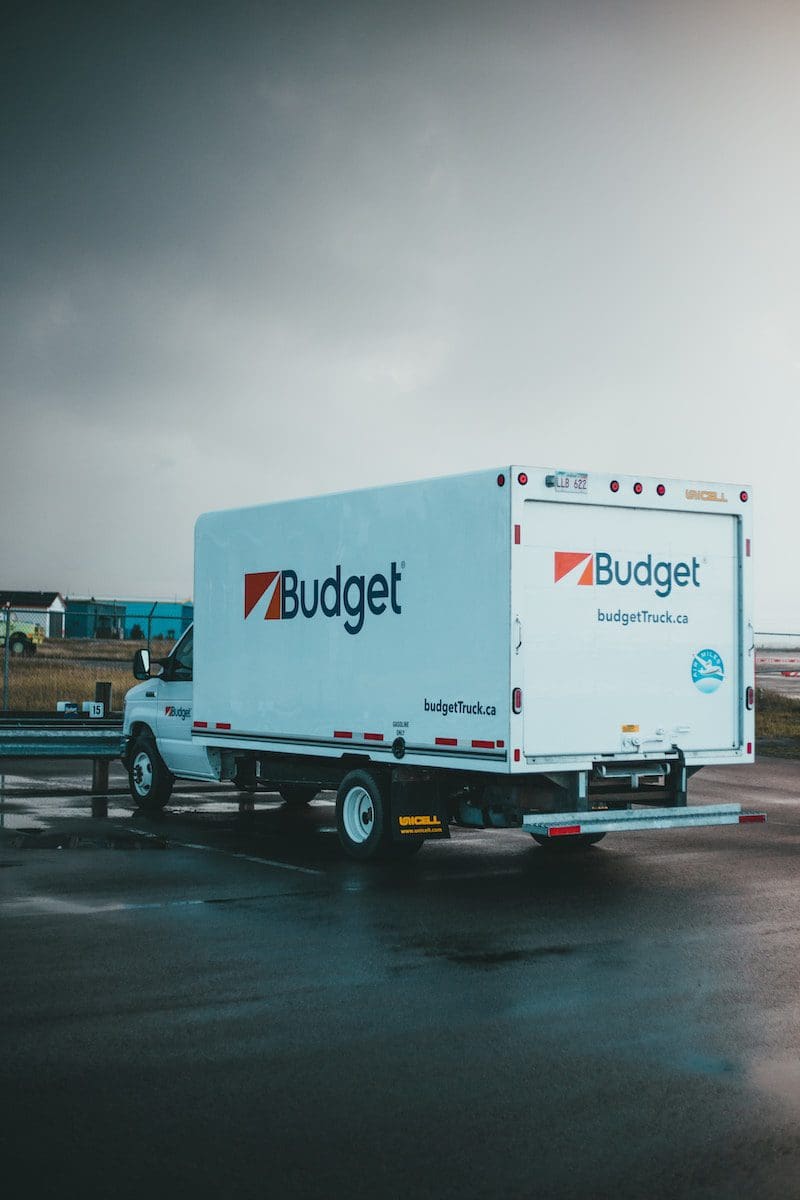 a blue and white budget truck parked in a parking lot