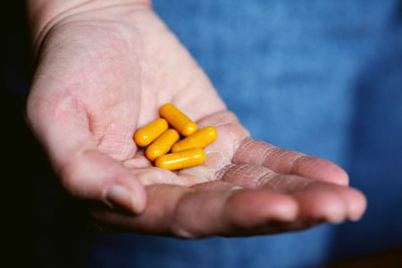 yellow thorne medication pills in persons hand